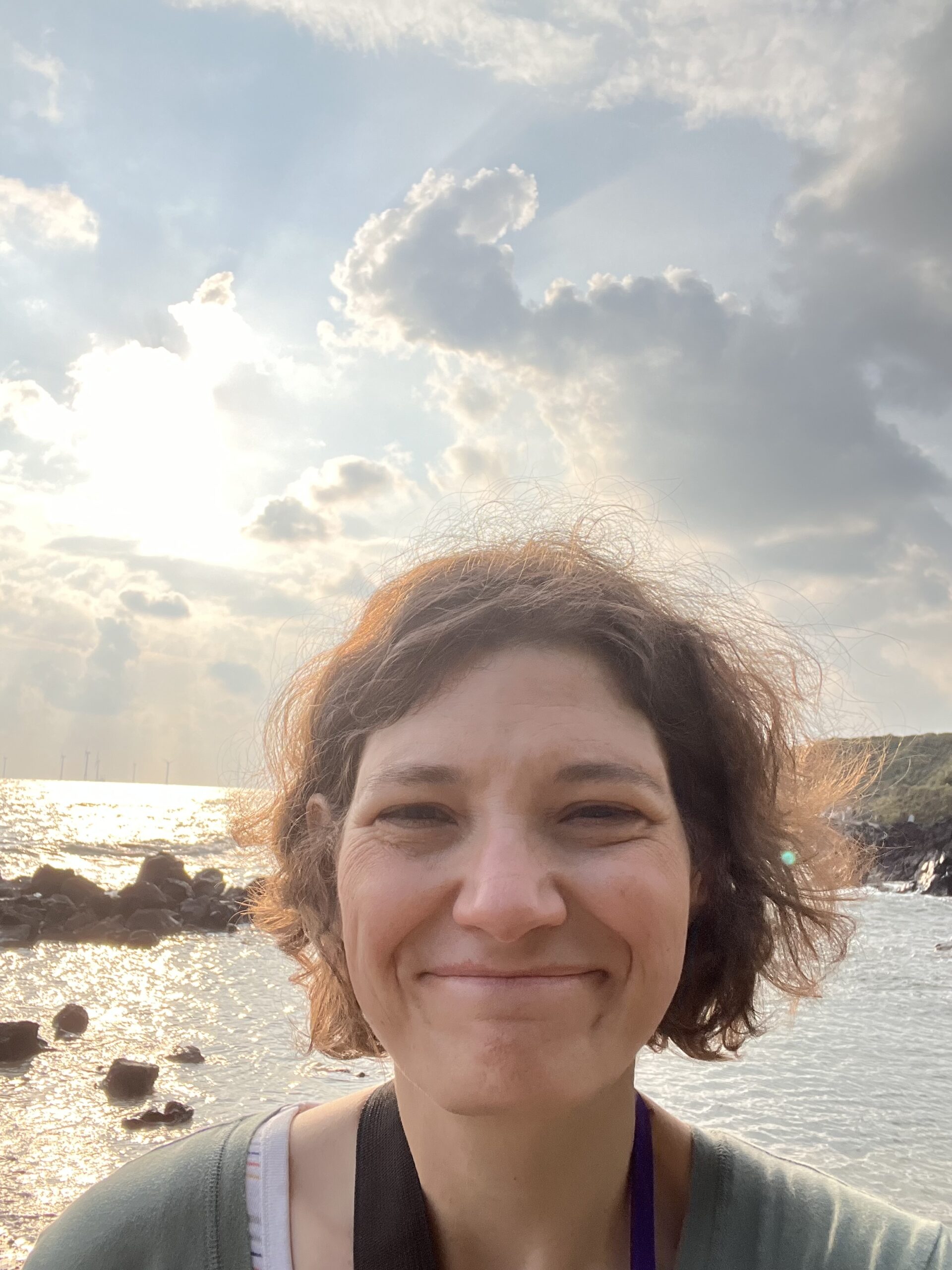 woman smiling in front of scenic ocean view